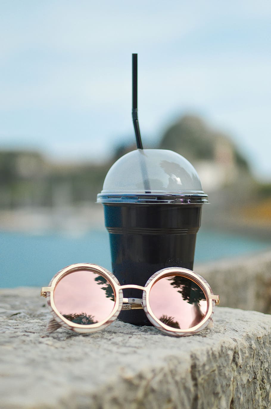 selective focus photography of black plastic cup beside sunglasses HD wallpaper