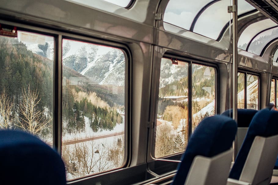 photo of white and green mountain surrounded by green and brown trees, empty train chairs HD wallpaper
