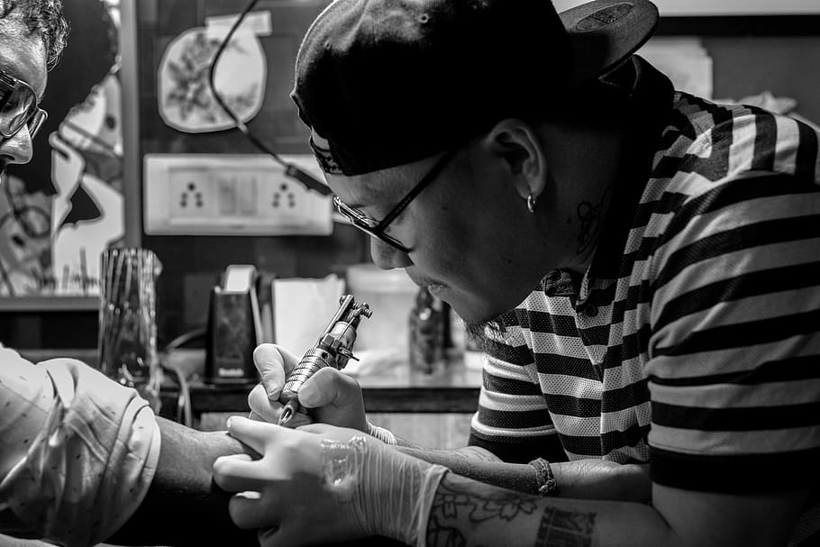 grayscale photo of man doing tattoo, artist, creative, tattooist