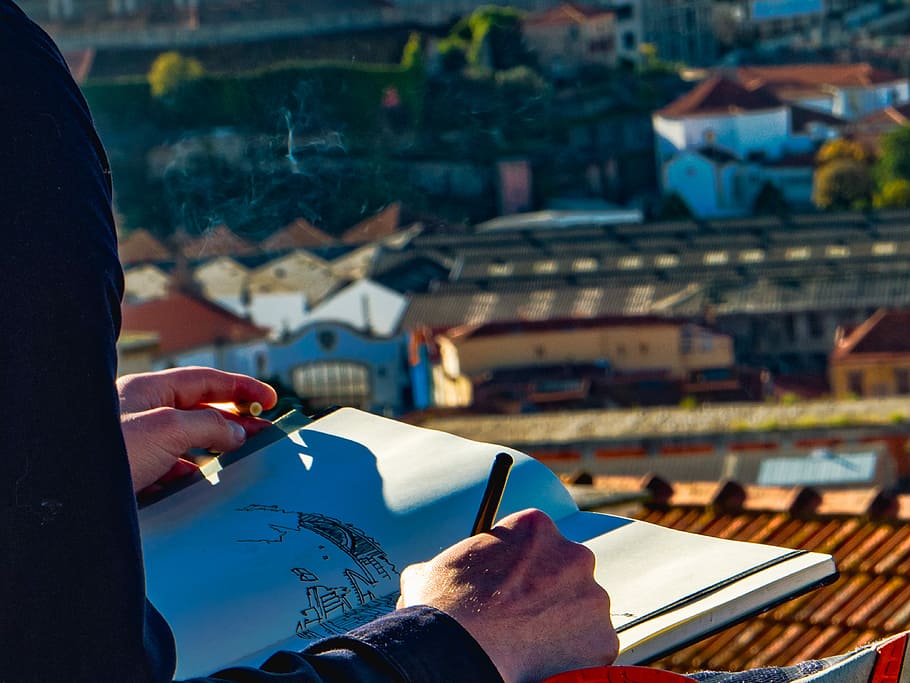 man sketching houses on roof, person holding pen while drawing during daytime, HD wallpaper