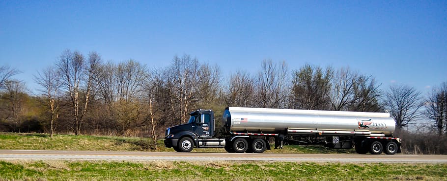 gray and black tanker truck traveling on road at daytime, tank truck
