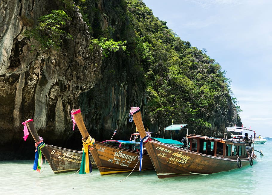 three brown wooden canoes boats, phi phi island tour, phuket