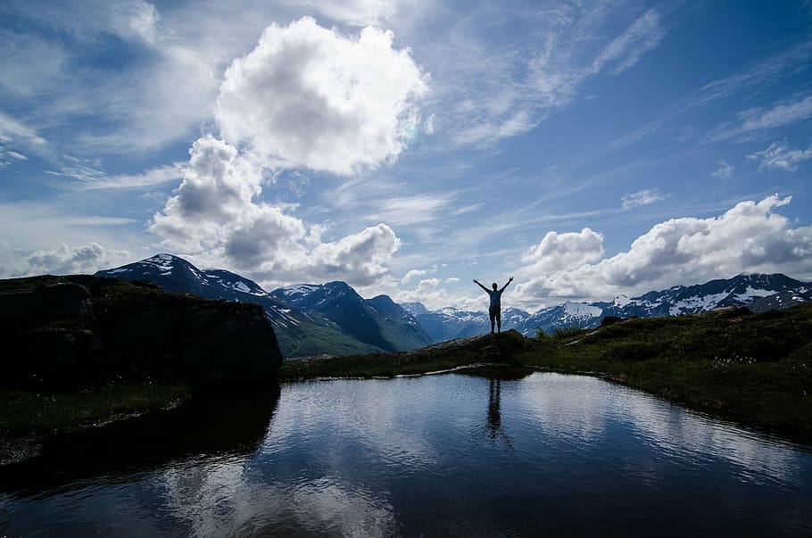 silhouette of person standing beside body of water, mountains HD wallpaper