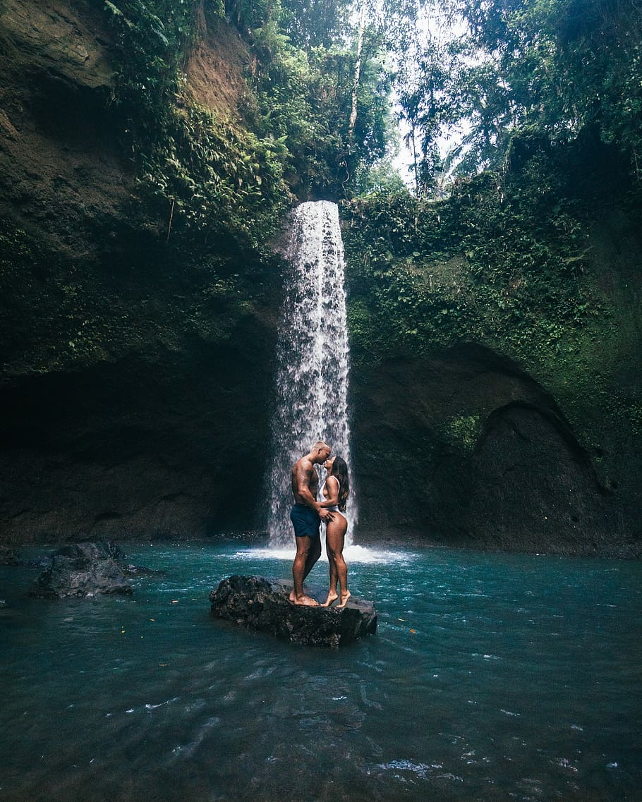 couple standing on rock about to kiss near waterfall during daytime, HD wallpaper
