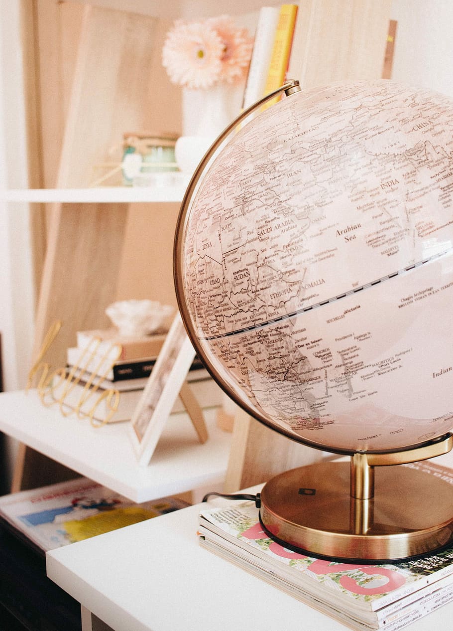 white and black desk globe on the top of magazines, brass-colored framed desk globe near white wooden photo frame, HD wallpaper