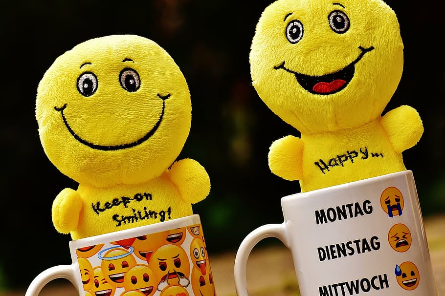 two emoticon plush toys on coffee mugs, smilies, cup, yellow