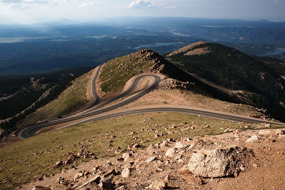 aerial photography of winding road, gray asphalt road on mountain during daytime HD wallpaper