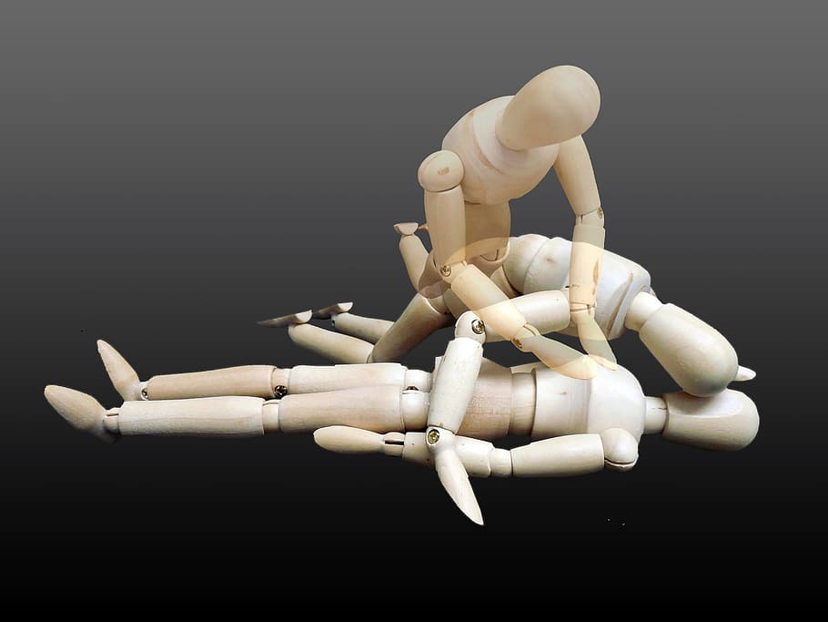 beige marionette on black surface, first aid, rescue, victims