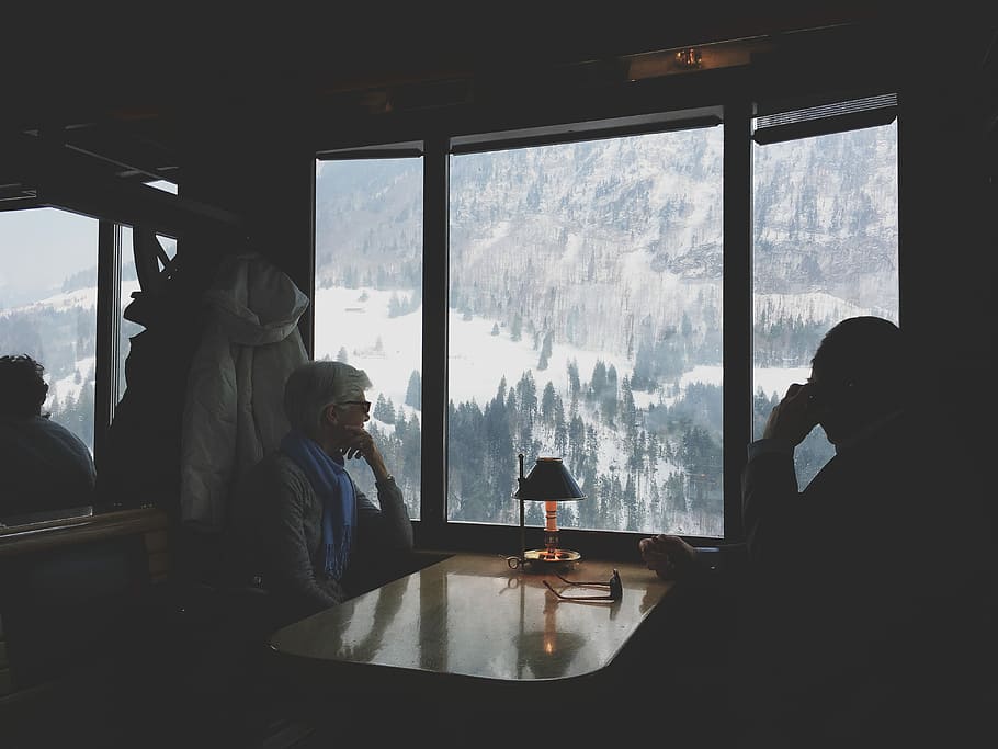 two person sitting at table watching the snow covered hill, person's infront of table HD wallpaper