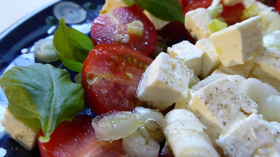 close-up photo of sliced tomato and vegetable leaf, salad, cheese