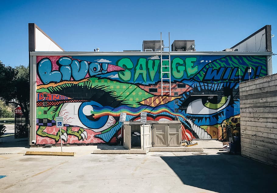 building with multi-colored graffiti, mural on wall, street art