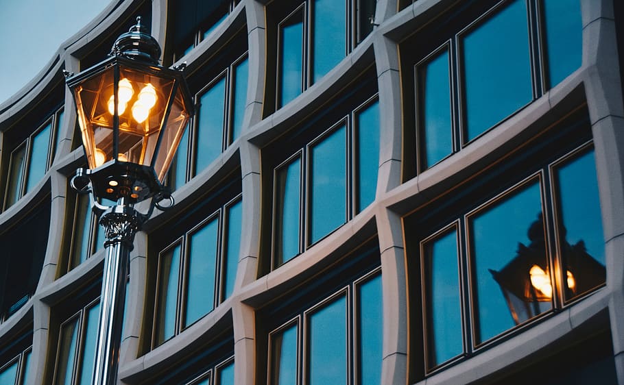 close-up photo of turned on black post lamp, black outdoor lantern beside curtain glass wall building HD wallpaper