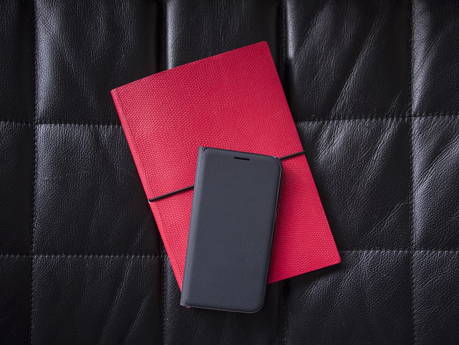 gray leather phone case, black smartphone case on red table case, HD wallpaper