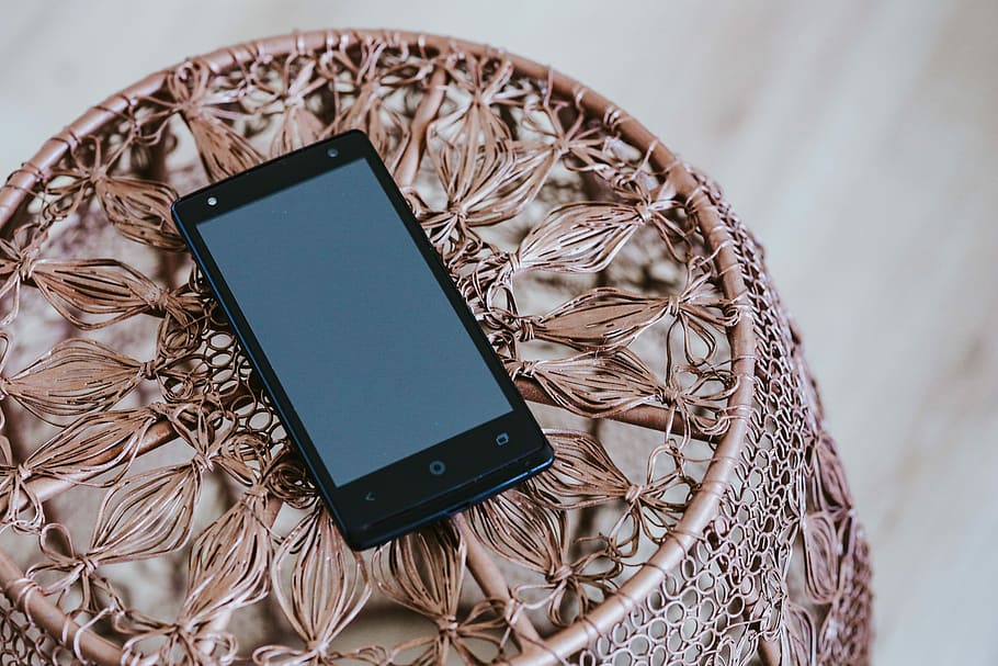 Black smartphone on a miniature brown table, coffee table, modern HD wallpaper