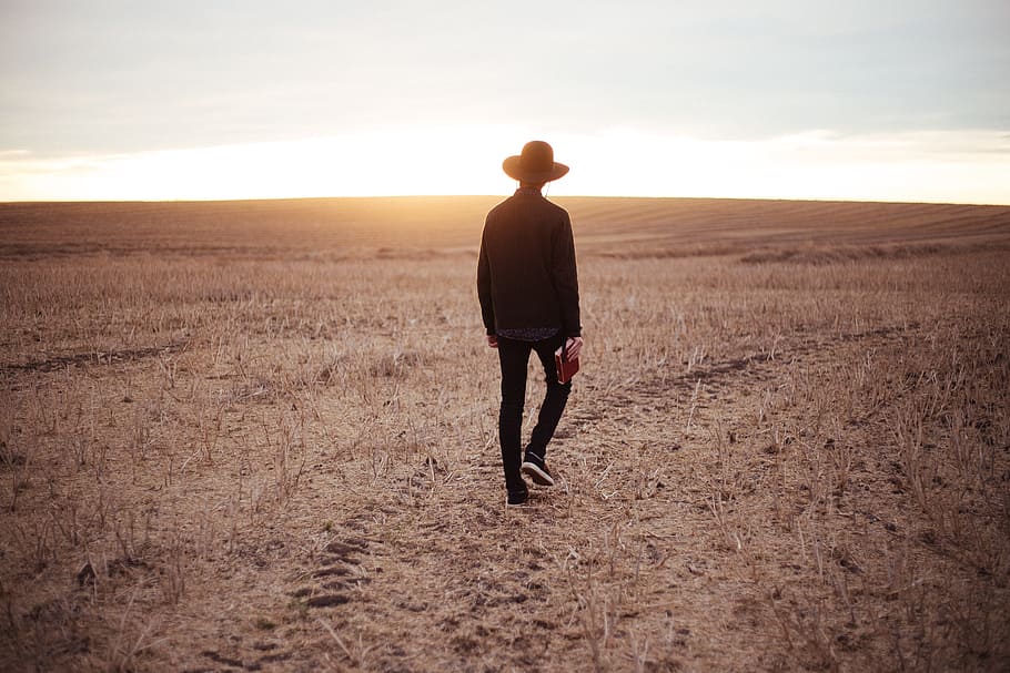 person walking in brown open field at daytime, man, guy, hat HD wallpaper