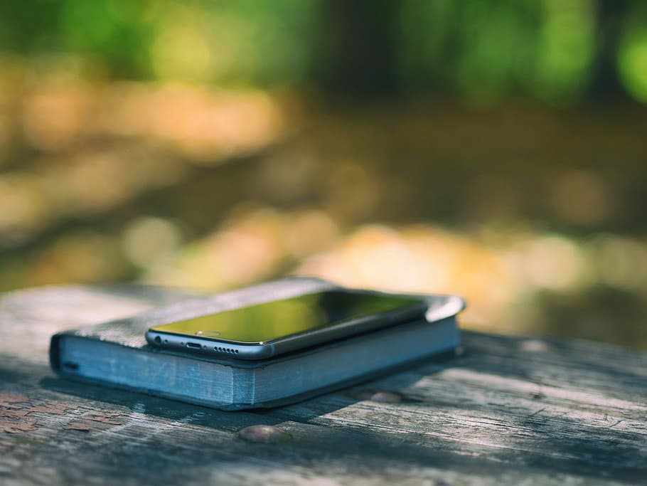 space gray iPhone 6 on top of black book photo, selective focus photo of space gray iPhone 6 on top of book at daytime HD wallpaper