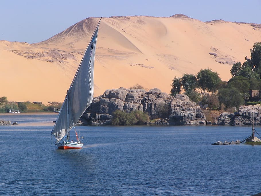 white sailboat near desert at daytime, nile, aswan, elephantine
