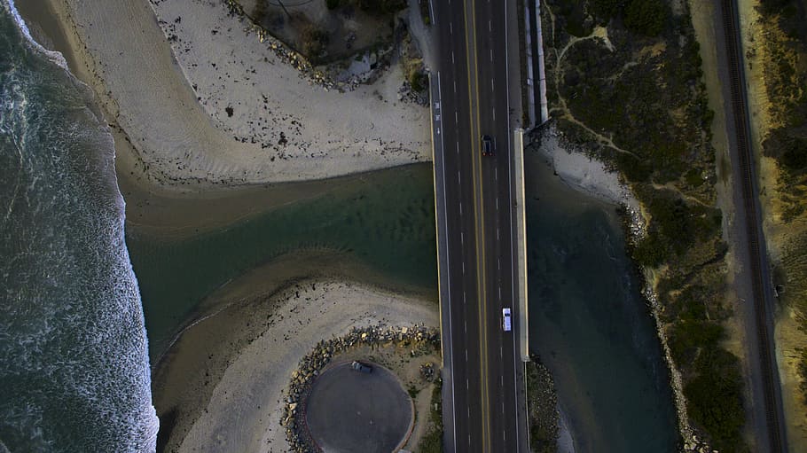 aerial photography of black and white vehicles on road between body of water and, aerial view of concrete road near body of water, HD wallpaper