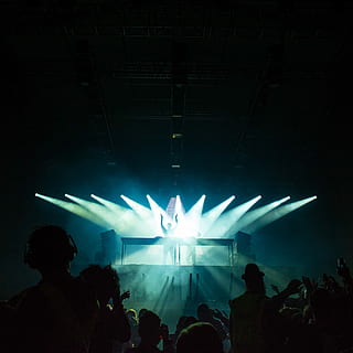 person standing under stage lights facing crowd, people dancing in front of stage HD wallpaper