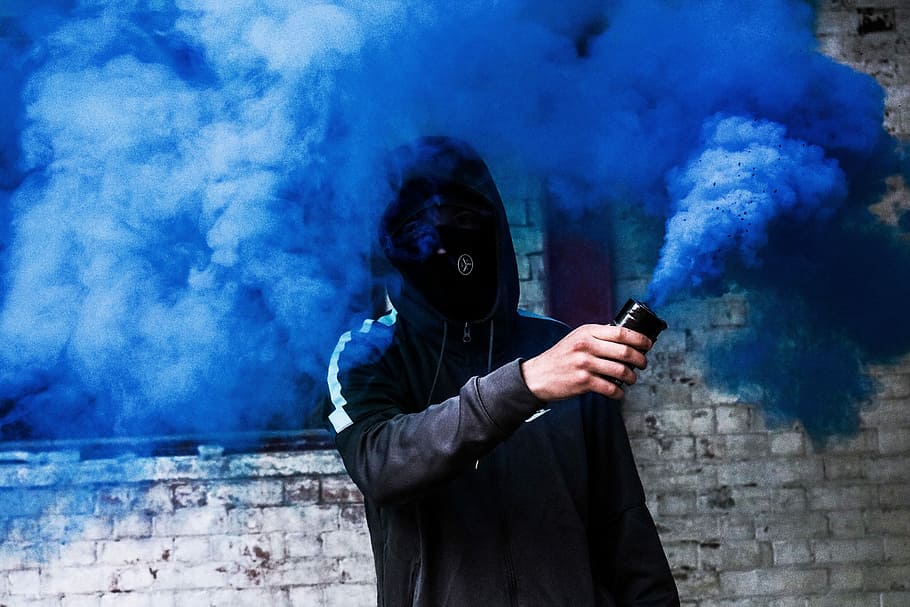 person covered with mask and hoodie using blue smoke, person holding blue smoke fragment, HD wallpaper