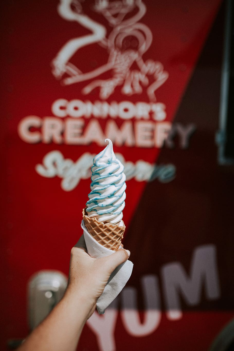 person holding ice cream cone in shallow photography, shallow focus photography of ice cream with cone