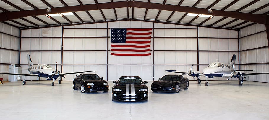 photo of three black vehicles and two white planes, corvette