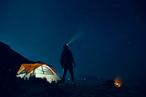 man standing beside camping tent wearing headlamp during nighttime, man using headlamp beside cabin tent HD wallpaper