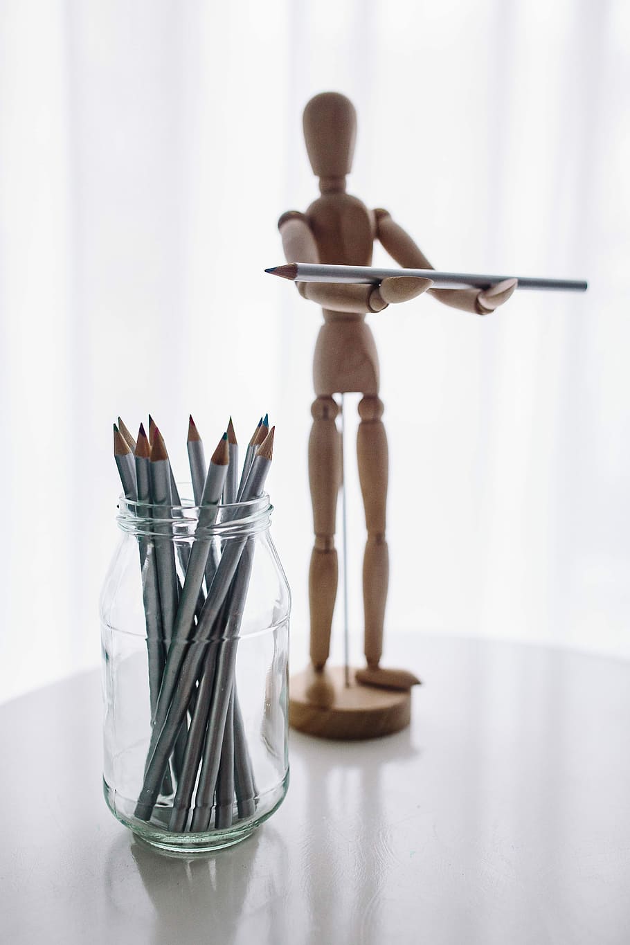 Wooden mannequin in various poses, hand, model, yarn, pencils