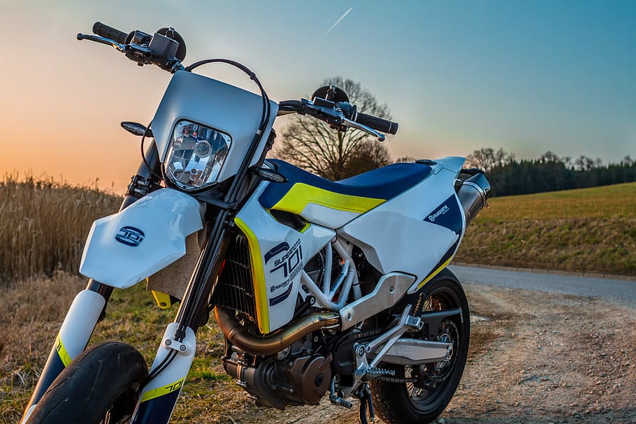 white and yellow dirt bike parked near green fields, motorcycle
