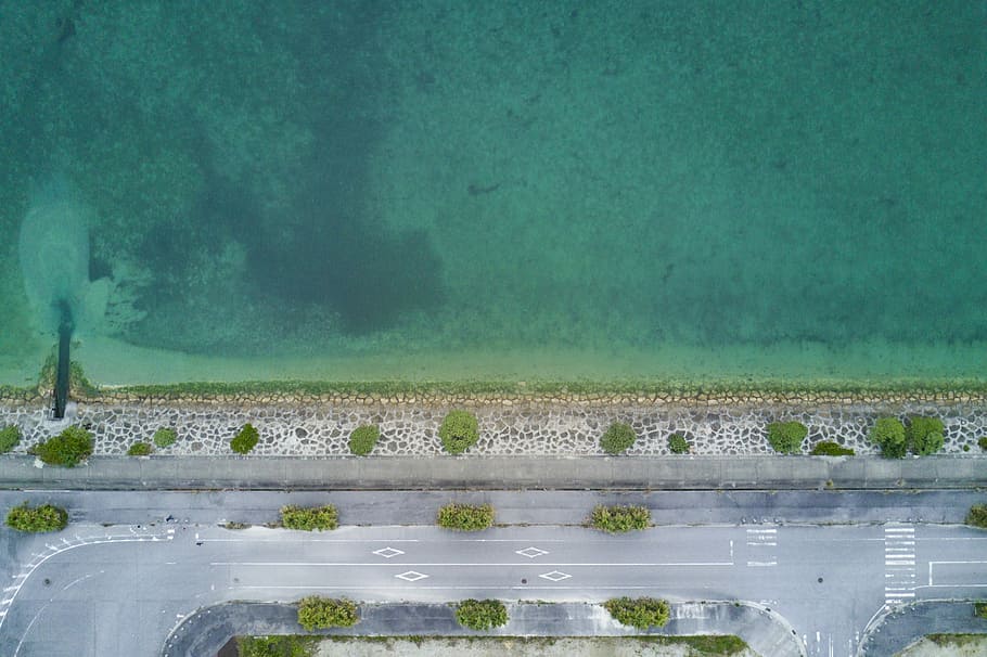 bird's photography of road near body of water, aerial photo of concrete road beside shoreline