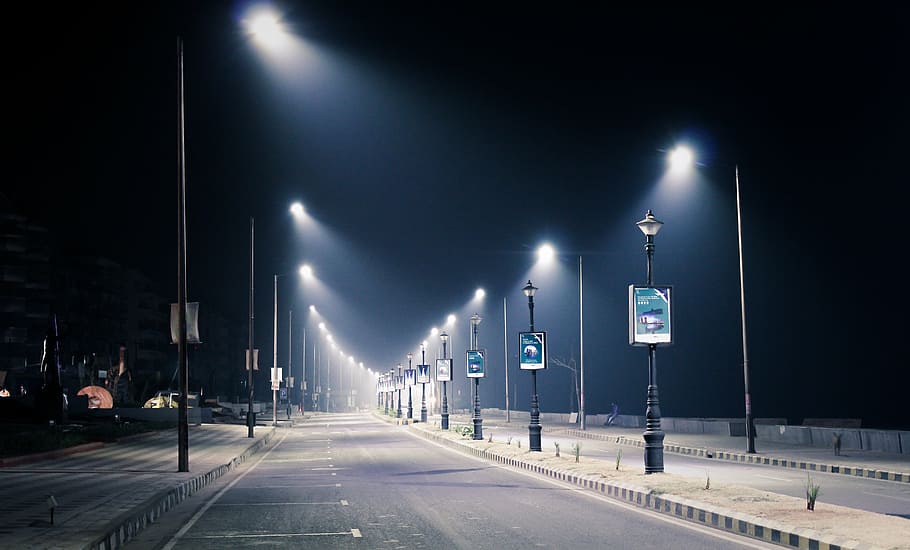 roadside parking lot with streetlamps during nighttime, streetlight