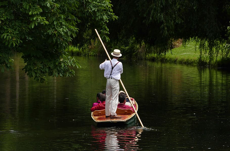 man rowing on boat with passengers sitting, punt boat, couple