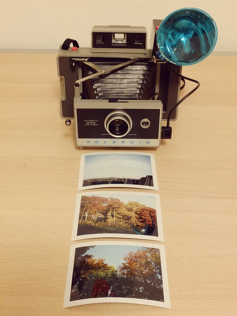 grey folding camera in front of three photographs, Polaroid HD wallpaper