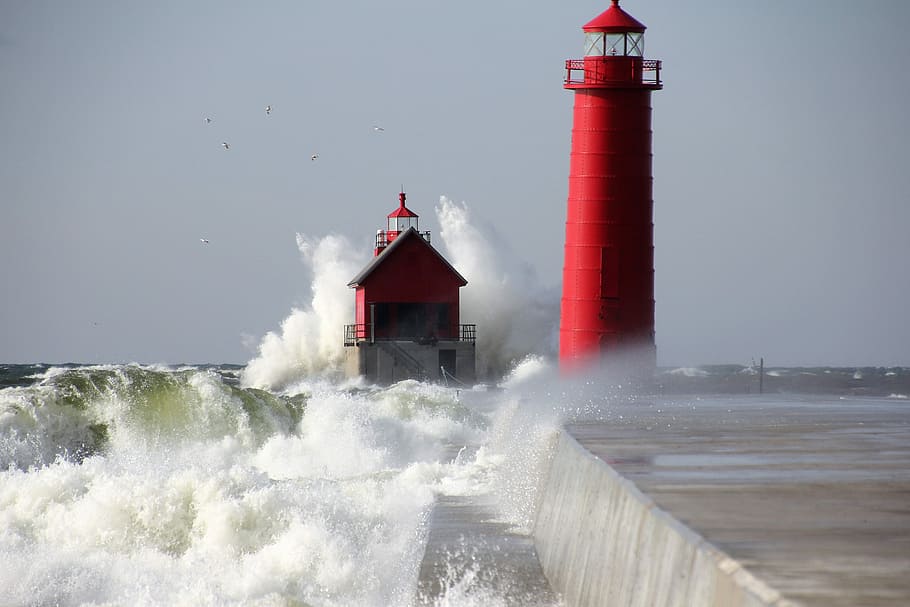red lighthouse near sea, time lapse photography of red lighthouse near body of water
