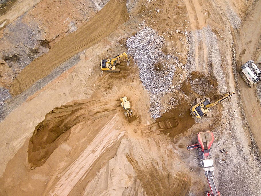 aerial photography of three heavy equipment, birds eye photography of heavy equipment on brown sand HD wallpaper
