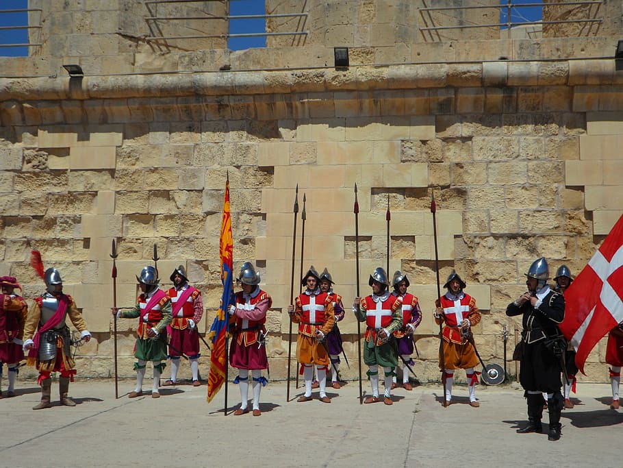 group of medieval knight cosplayers standing in front of brick wall