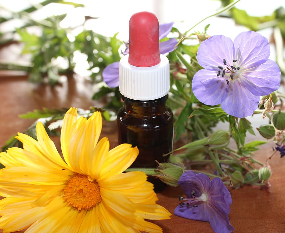 medicine drop bottle in between assorted flowers, natural medicine