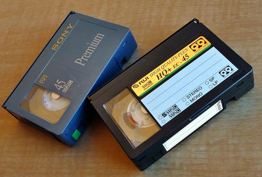 two gray Sony and Fuji cassette tapes on brown wooden surface