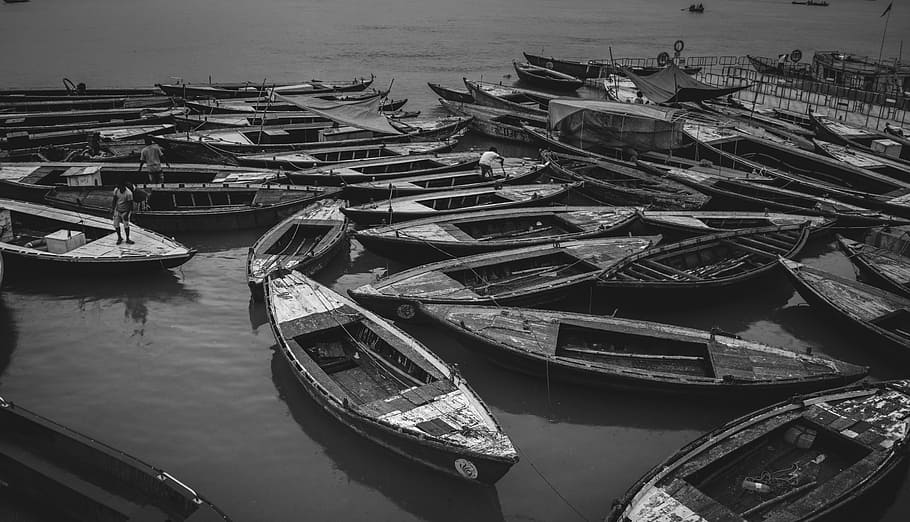 grayscale photo of boats on water, grayscale photography of canoe boats on body of water