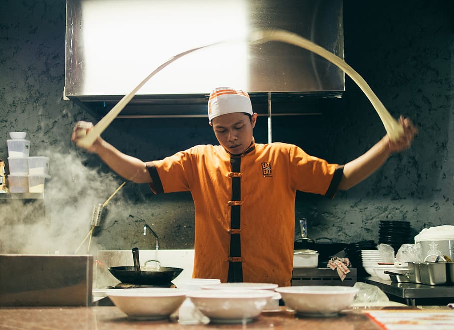 person in orange and black chef uniform baking, asian cuisine
