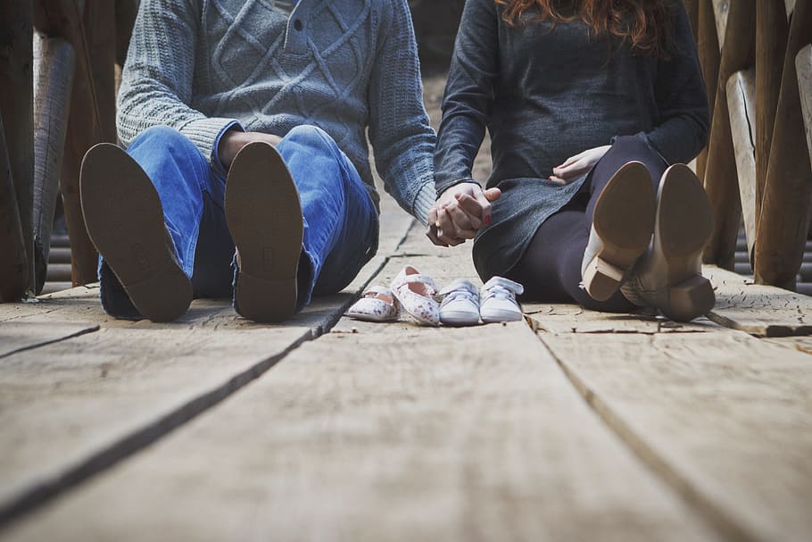 Waitimg for the twins, man and woman holding hands while sitting on wooden pathway HD wallpaper
