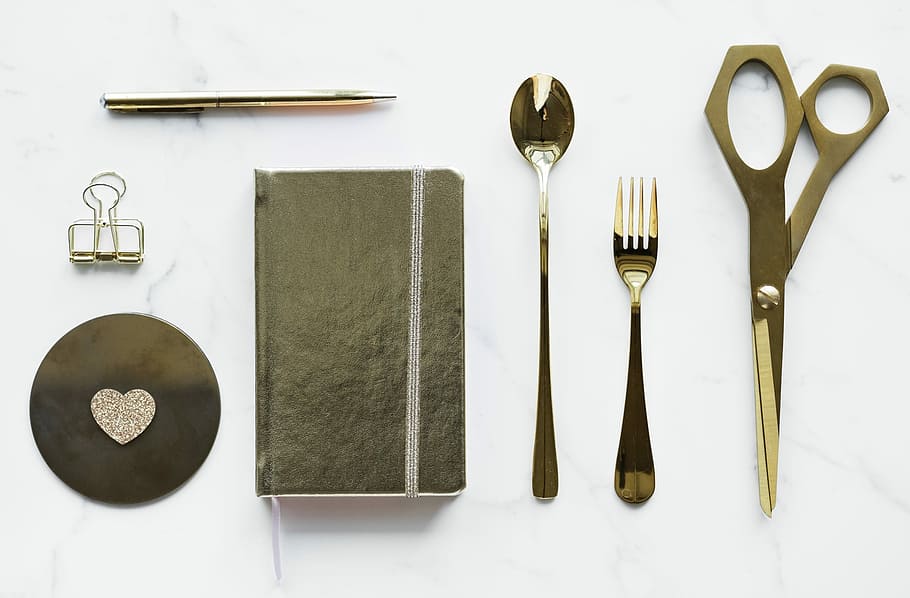 top view photo of book between kitchen utensils and binder clip HD wallpaper