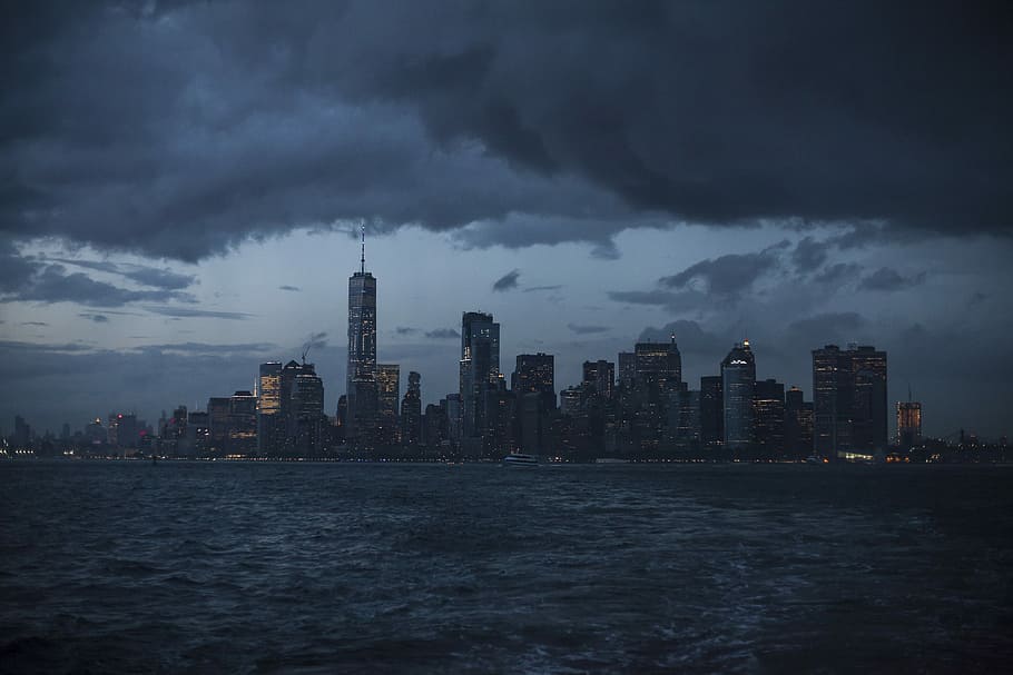 body of water under cloudy sky during daytime, city buildings with gray cloudy sky \ HD wallpaper