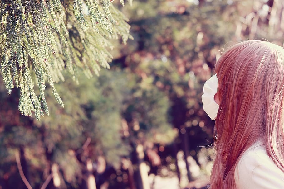 woman wearing white face mask and facing near green leaf tree HD wallpaper