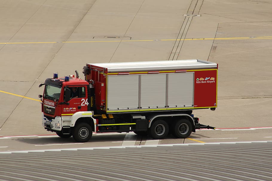 white and red truck travelling on airport plane runway, fire