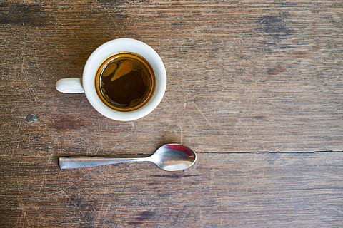 white ceramic teacup and gray spoon on brown wooden surface HD wallpaper