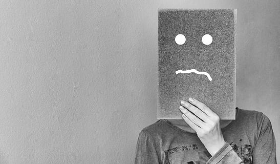 person holding board with sad face painting, at a loss, uncertain HD wallpaper