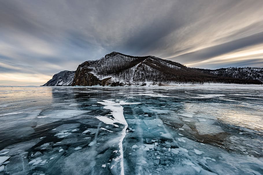 melting ice on water near gray mountain at daytime, frozen body of water leading to island HD wallpaper