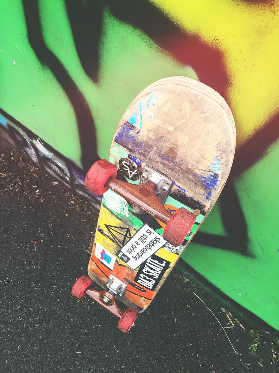 skateboard on graffiti wall, skateboard leaning on the wall, urban