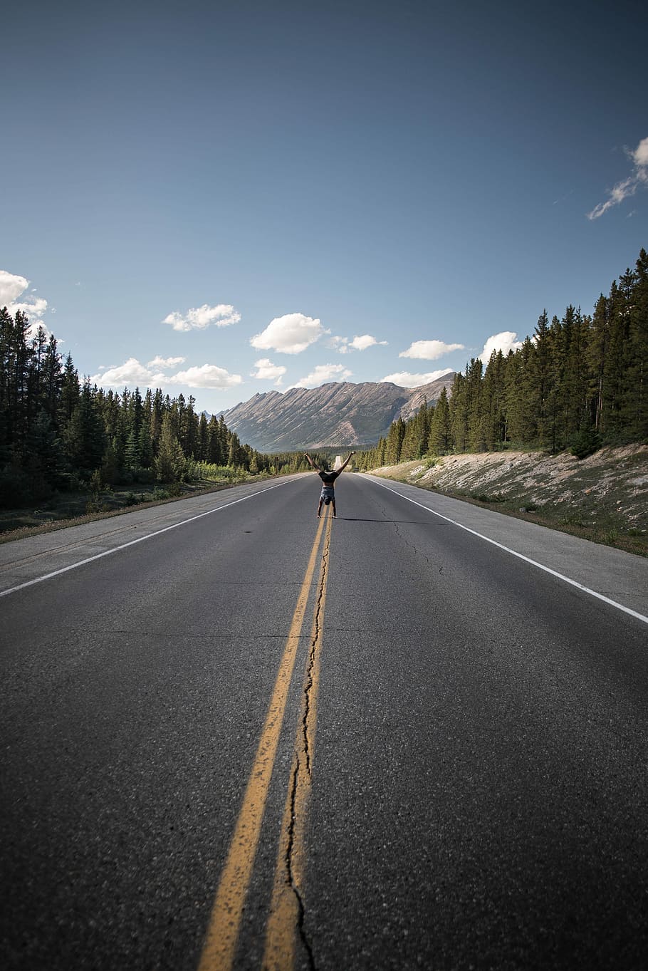 man doing handstand on gray pavement, person doing stunt in the middle of road HD wallpaper